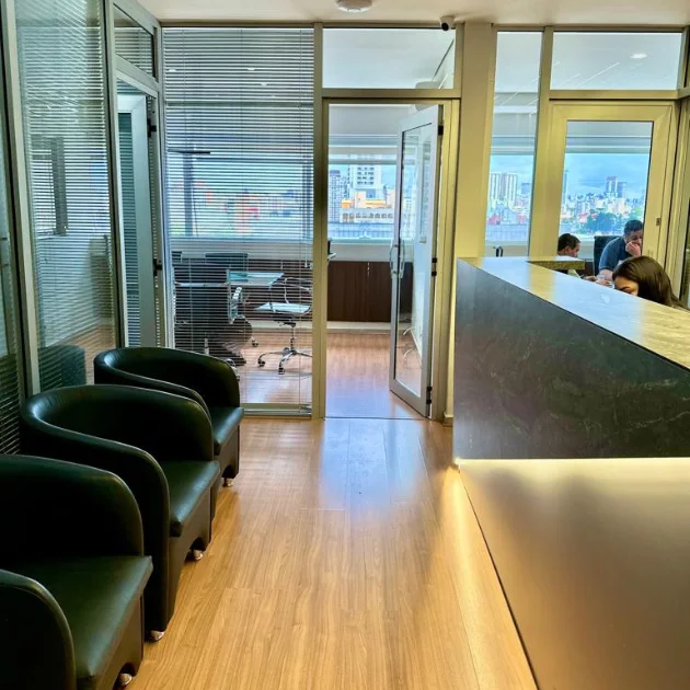 Recepção do escritório, com poltronas de espera e balcão